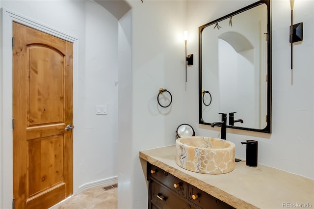 bathroom with vanity, visible vents, and baseboards