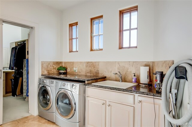 washroom with washer and dryer, a healthy amount of sunlight, and a sink