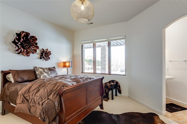 bedroom featuring arched walkways, visible vents, and baseboards