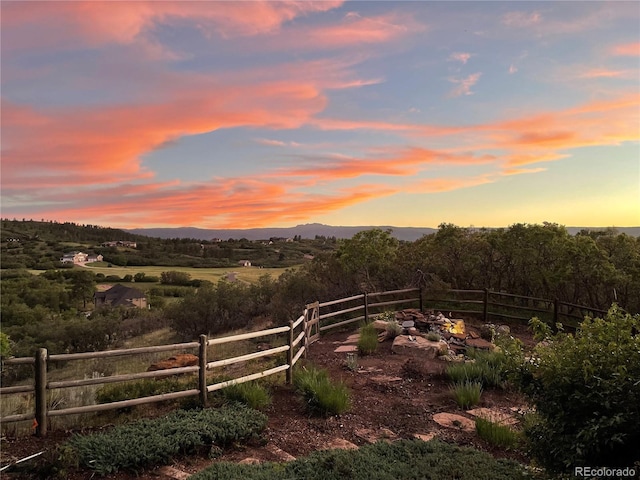 yard at dusk with fence and a mountain view