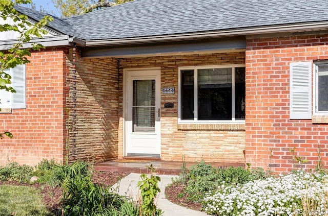 property entrance with brick siding and a shingled roof