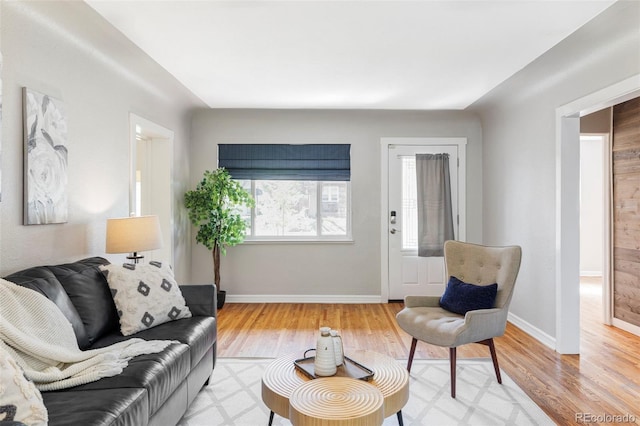 living area featuring light wood-style flooring and baseboards