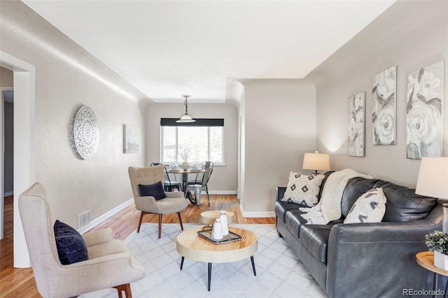 living room with light wood-type flooring and baseboards