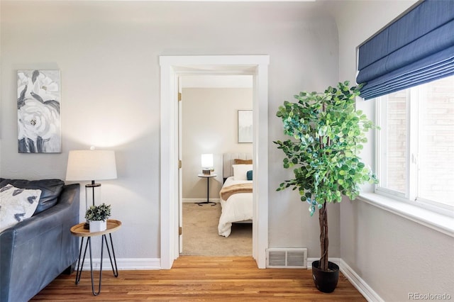corridor with light wood-type flooring and baseboards