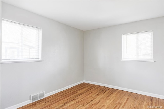 unfurnished room with light wood-type flooring and baseboards