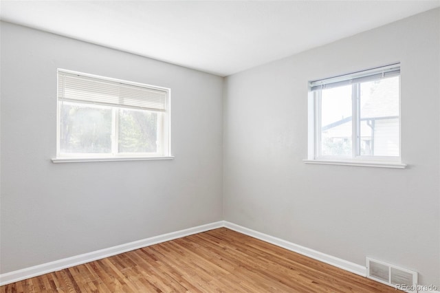 spare room with baseboards and light wood-style floors