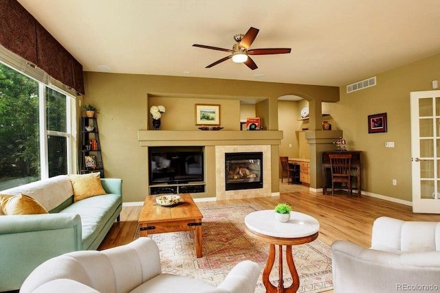 14200 W 86th Pl, Arvada, CO 80005 - living room with a fireplace, wood finished floors, ceiling fan, baseboards, and arched walkways