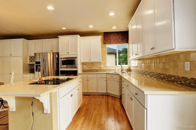 14200 W 86th Pl, Arvada, CO 80005 - kitchen with stainless steel appliances, a center island, light wood-style floors, a sink, and recessed lighting