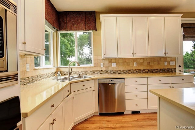 14200 W 86th Pl, Arvada, CO 80005 - kitchen with stainless steel dishwasher, a sink, healthy amount of natural light, and light countertops
