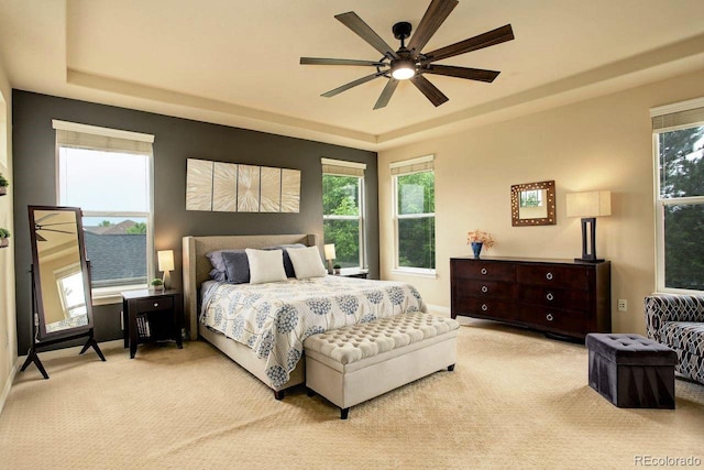 14200 W 86th Pl, Arvada, CO 80005 - carpeted bedroom featuring a tray ceiling, multiple windows, ceiling fan, and baseboards