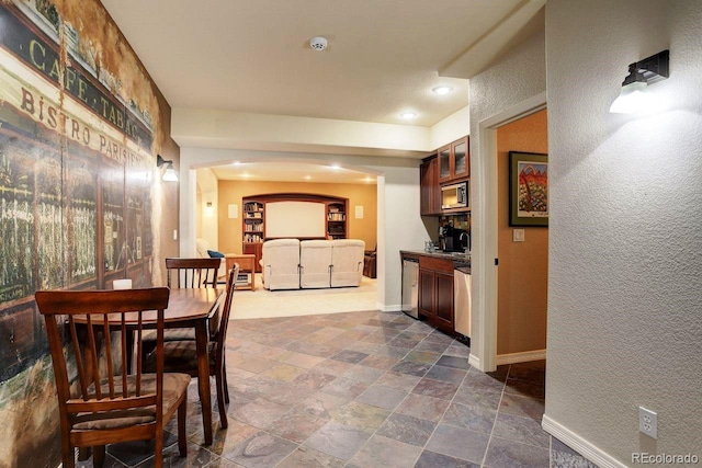 14200 W 86th Pl, Arvada, CO 80005 - dining area featuring stone tile floors, baseboards, arched walkways, a textured wall, and recessed lighting