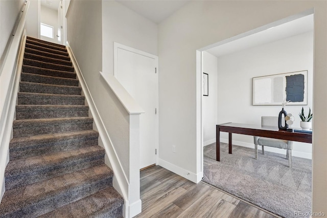 stairs featuring wood finished floors and baseboards