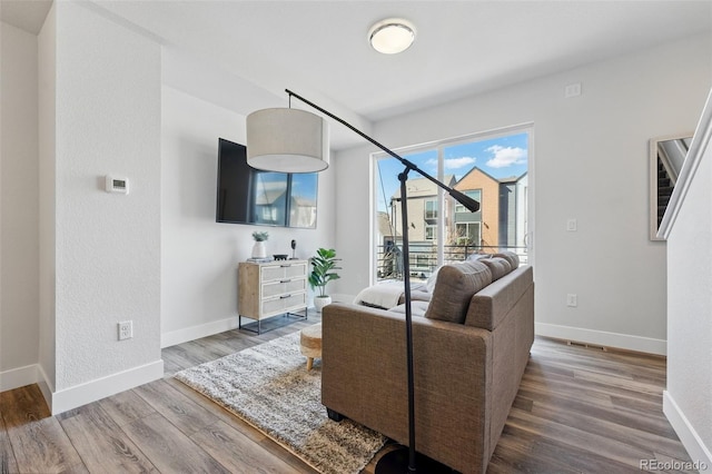 living room featuring visible vents, wood finished floors, and baseboards