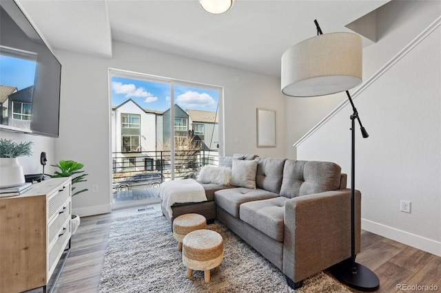 living area featuring visible vents, wood finished floors, and baseboards