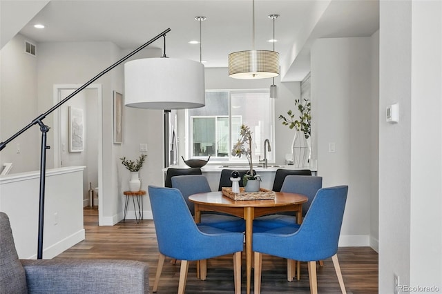 dining area with visible vents, baseboards, wood finished floors, and stairs