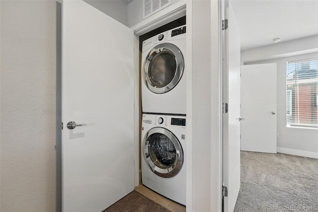 washroom with laundry area, stacked washer / dryer, visible vents, and carpet floors