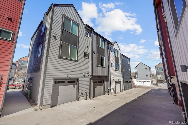 exterior space with board and batten siding, a garage, and a residential view