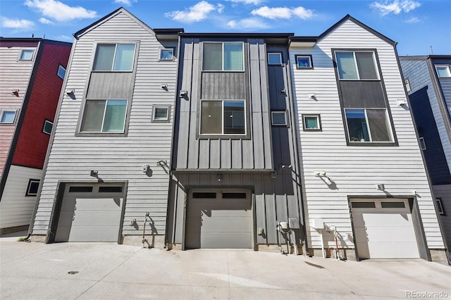 view of property with board and batten siding, an attached garage, and concrete driveway