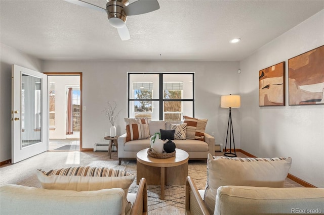 living area with a baseboard radiator, light carpet, a textured ceiling, and baseboards