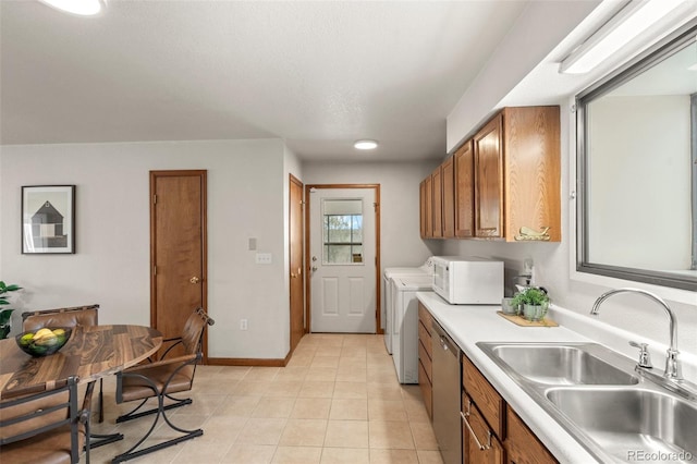 kitchen featuring brown cabinetry, independent washer and dryer, a sink, and white microwave