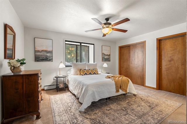 bedroom featuring light carpet, baseboard heating, two closets, and a textured ceiling