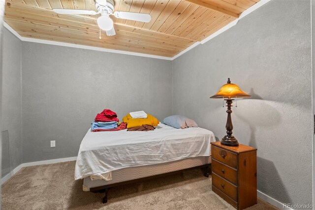 bedroom with a ceiling fan, wood ceiling, baseboards, ornamental molding, and carpet