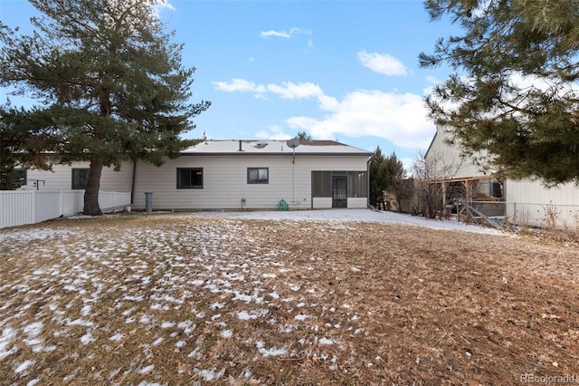 rear view of property featuring a sunroom and fence