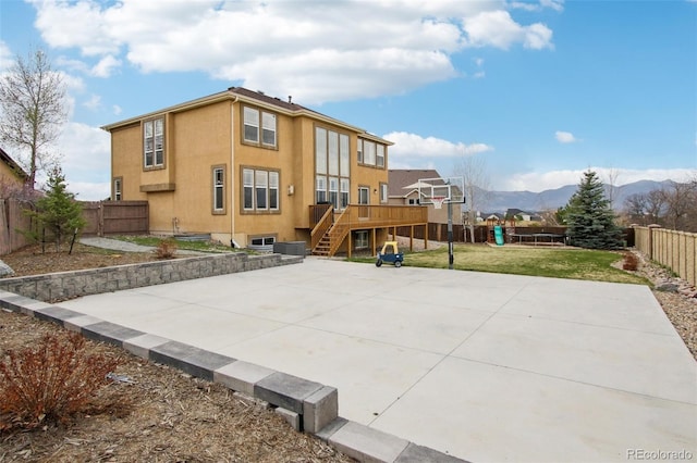 10725 Black Elk Way, Colorado Springs, CO 80908 - back of property featuring basketball court, a fenced backyard, a mountain view, stucco siding, and stairs
