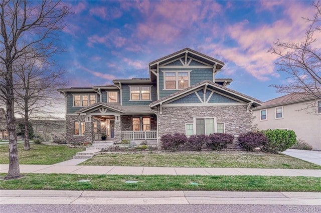 10459 Rivington Ct, Lone Tree, CO 80124 - craftsman-style house with stone siding, a porch, and a front yard