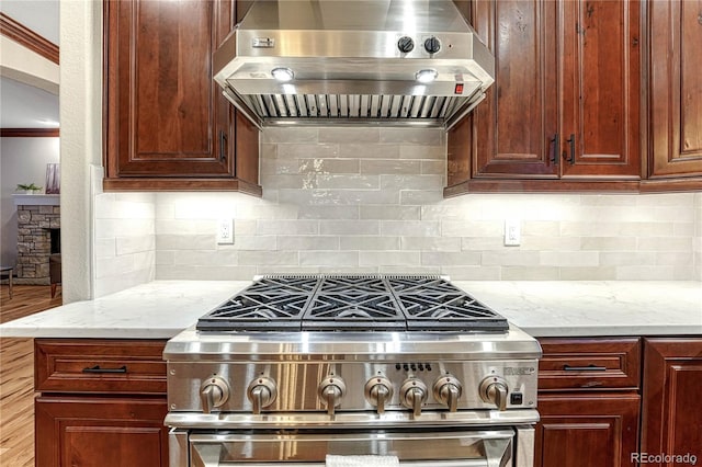 10459 Rivington Ct, Lone Tree, CO 80124 - kitchen with extractor fan, high end stainless steel range, light stone countertops, decorative backsplash, and ornamental molding