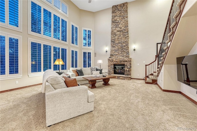 10459 Rivington Ct, Lone Tree, CO 80124 - carpeted living area featuring a high ceiling, a stone fireplace, a ceiling fan, baseboards, and stairs