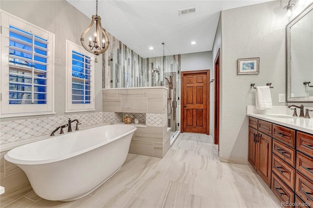 10459 Rivington Ct, Lone Tree, CO 80124 - bathroom featuring a shower stall, a freestanding bath, vanity, a chandelier, and a textured wall