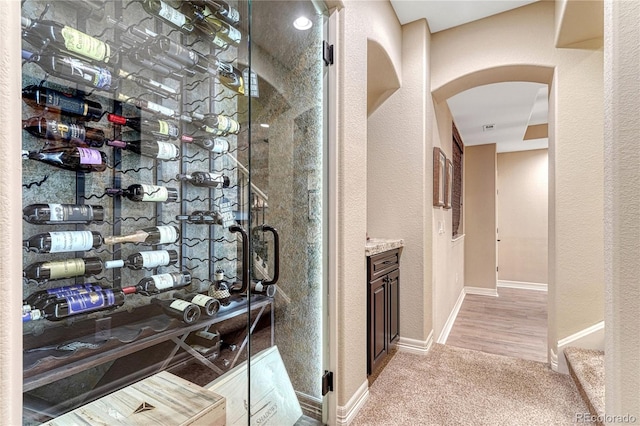 10459 Rivington Ct, Lone Tree, CO 80124 - wine room featuring arched walkways, light carpet, and baseboards