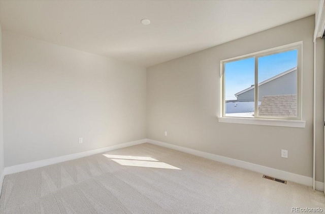 carpeted empty room featuring baseboards
