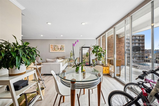 dining area with expansive windows, ornamental molding, light wood-type flooring, and recessed lighting