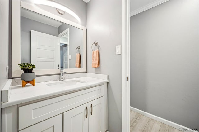 bathroom with vanity, baseboards, and wood finished floors