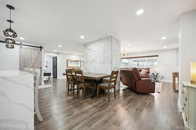 dining area featuring wood-type flooring and a barn door