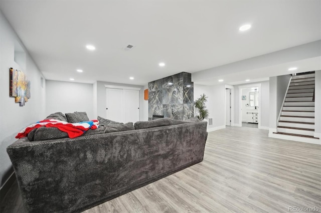 living room with a fireplace and light wood-type flooring