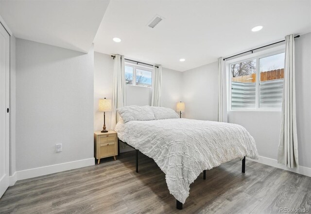 bedroom with wood-type flooring and multiple windows