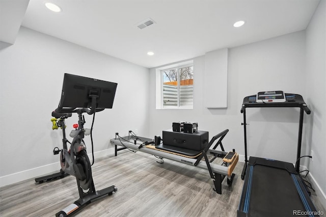 exercise room with light hardwood / wood-style floors