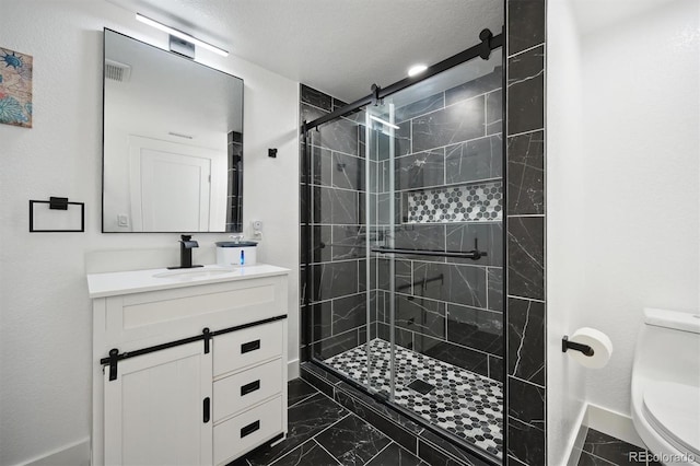 bathroom with toilet, a textured ceiling, a shower with shower door, and vanity