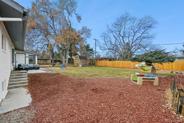 view of yard featuring an outdoor hangout area, a playground, and a storage shed