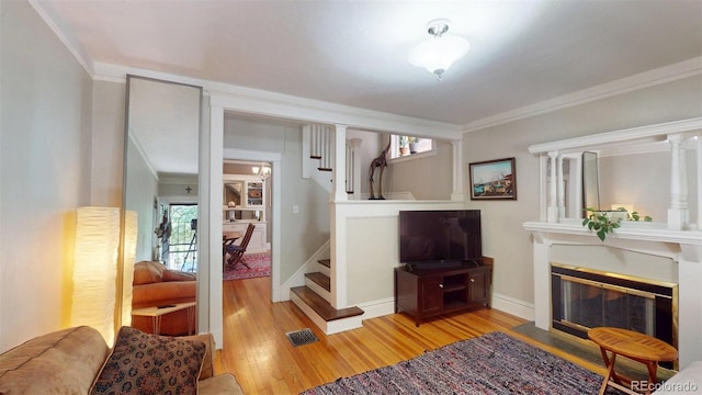126 S Clarkson St, Denver, CO 80209 - living area with wood finished floors, stairs, plenty of natural light, ornamental molding, and a fireplace with flush hearth
