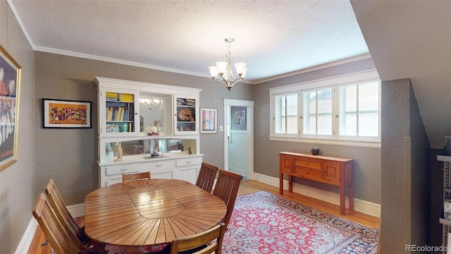 126 S Clarkson St, Denver, CO 80209 - dining room with a chandelier, light wood-type flooring, and crown molding