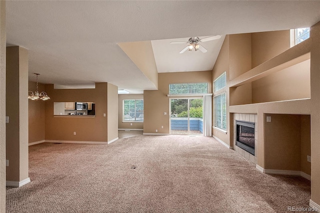 1419 Red Mountain Dr Unit 126, Longmont, CO 80504 - unfurnished living room with carpet flooring, a ceiling fan, a tiled fireplace, and a chandelier