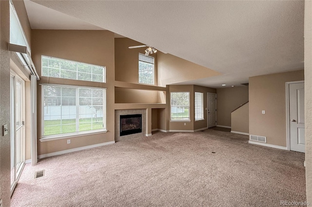 1419 Red Mountain Dr Unit 126, Longmont, CO 80504 - unfurnished living room featuring carpet flooring, high vaulted ceiling, a fireplace, plenty of natural light, and a textured ceiling
