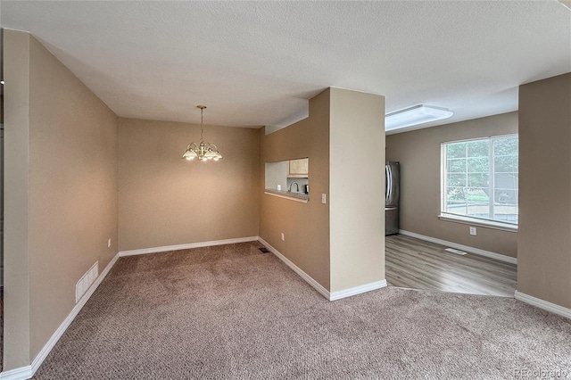1419 Red Mountain Dr Unit 126, Longmont, CO 80504 - empty room with carpet flooring, a chandelier, and a textured ceiling