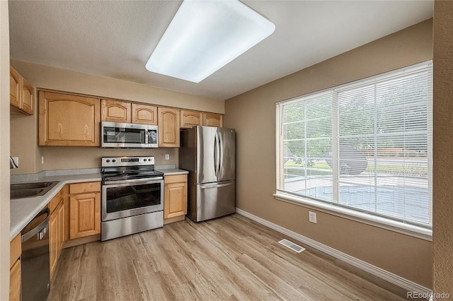 1419 Red Mountain Dr Unit 126, Longmont, CO 80504 - kitchen with stainless steel appliances, light countertops, light wood-style floors, and light brown cabinets