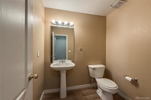 1419 Red Mountain Dr Unit 126, Longmont, CO 80504 - half bathroom featuring toilet and wood finished floors