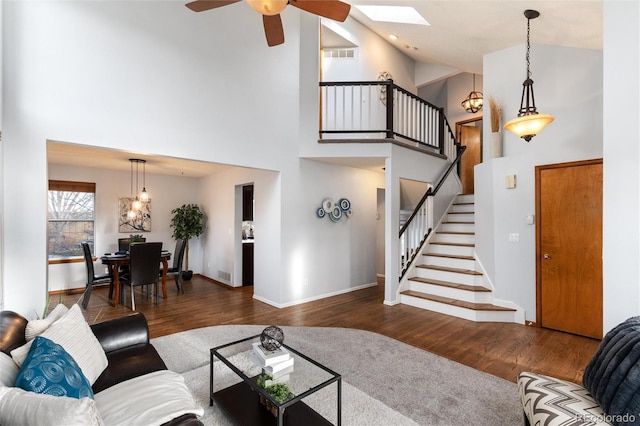 7636 S Allison Ct, Littleton, CO 80128 - living room with high vaulted ceiling, wood finished floors, stairs, a skylight, and a ceiling fan